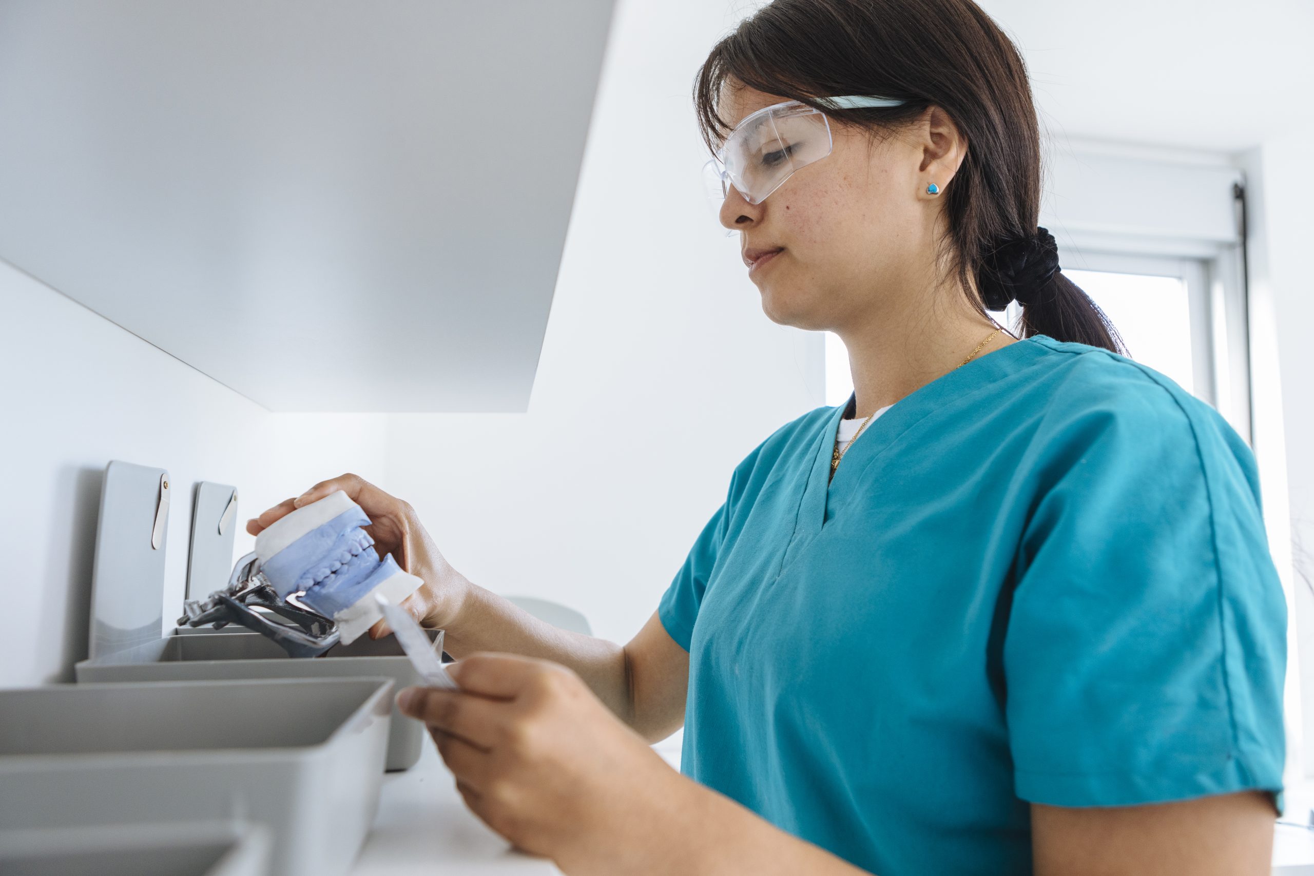 A closeup shot of a female doctor checking a denture tool