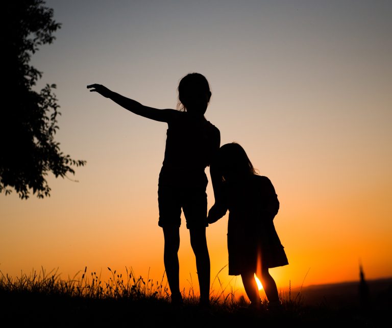 Silhouette of two young sisters