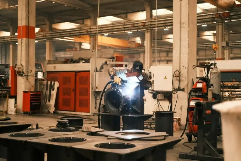 A man welding a piece of metal in a factory